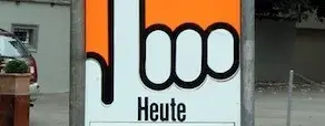 Auf einem Schild steht "Heute Abstimmung" auf einer Hand, welche den Zeigefinger erhoben hat.