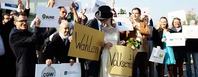 Die Braut und der Bräutigam mit dem Plakaten küssen sich jetzt auf dem Foto.