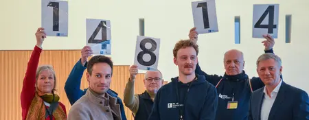 Auf dem Bild sind sieben Personen zu sehen, welche die Zahl 14814 hochhalten.