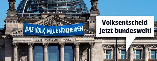 Auf dem Bild ist der Bundestag, wo über dem Eingang ein Banner mit dem Text "DAS VOLK WILL ENTSCHEIDEN" steht.
