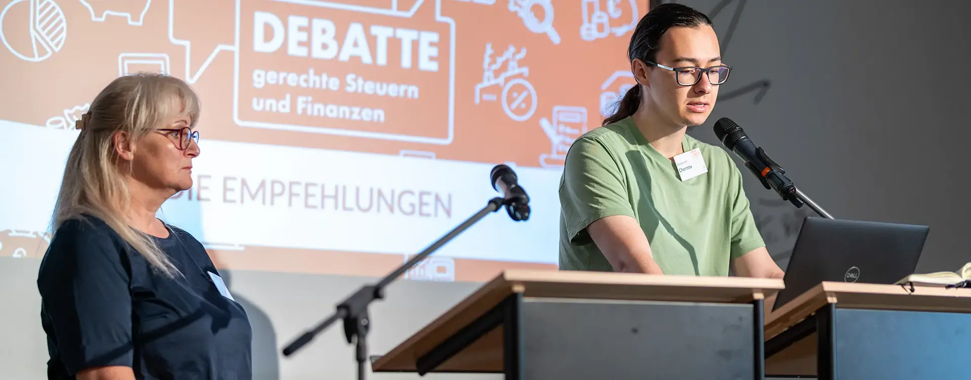 Eine junge Frau spricht vor einem Rednerpult auf dem Bild.